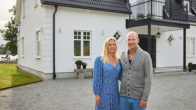 Ett par framför sitt stenhus med putsad fasad